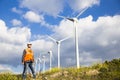 Young engineers looking and checking wind turbines at field Royalty Free Stock Photo