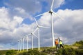 Young engineers looking and checking wind turbines at field Royalty Free Stock Photo