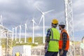 Young engineers looking and checking wind turbines at field Royalty Free Stock Photo