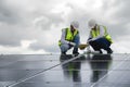 Young Engineers and Specialist Technicians Discuss and Check Detail of Installing Solar Photovoltaic Panels and Use App Technology Royalty Free Stock Photo