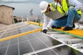 Young Engineers and Specialist Technicians Discuss and Check Quality of Installing Solar Photovoltaic Panels and Use App