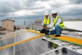 Young Engineers and Technicians Discuss and Check Quality of Installing Solar Photovoltaic Panels and Use App Technology Checking Royalty Free Stock Photo