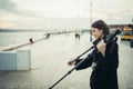 Young enthusiastic female photographer setting up lightweight carbon travel tripod for sunset/sunrise log exposure still shot Royalty Free Stock Photo