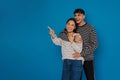 Young enthusiastic stylish guy hugging his happy beautiful asian girlfriend Royalty Free Stock Photo