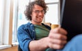 Young entrepreneur sitting in the office talking on mobile phone while working on a laptop. Royalty Free Stock Photo