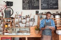 Young entrepreneur standing in his cafe using a digital tablet