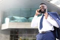 Young entrepreneur standing outside the office and talking on the mobile phone. Copy space Royalty Free Stock Photo