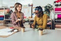 Young entrepreneur women, or fashion designers working in atelier and making short breakfast break at work Royalty Free Stock Photo