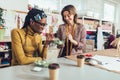 Young entrepreneur women, or fashion designers working in atelier and making short breakfast break at work Royalty Free Stock Photo