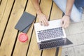 Young entrepreneur working at the park outside on wooden bench. Closeup view above of man hands on laptop keyboard Royalty Free Stock Photo