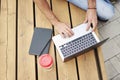 Young entrepreneur working at the park outside on wooden bench. Closeup view above of man hands on laptop keyboard Royalty Free Stock Photo