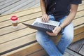 Young entrepreneur working at the park outside on wooden bench.Young entrepreneur working at the park outside on wooden bench.