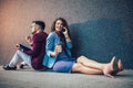 Entrepreneurs sitting down in front of a modern office building and using phone. Brainstorming outside in a beautiful day Royalty Free Stock Photo