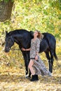 Young equestrian woman walking horse in autumn park Royalty Free Stock Photo