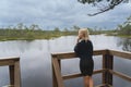 A young Estonian girl at a swimming spot in a swamp, the sky is overcast