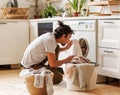 Young african american male householder loading washing machine