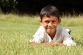 Young ethnic boy lying on the grass in park