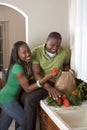 Young ethnic couple on kitchen sorting groceries Royalty Free Stock Photo