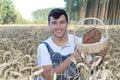 Young ethnic farmer holding bread in natural environment Royalty Free Stock Photo