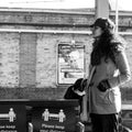 Young Ethnic Woman Standing Alone Waiting For A Train On Clapham Junction Station Platform Royalty Free Stock Photo