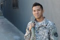 Young ethnically ambiguous American soldier holding backpack