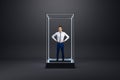 Young businessman standing inside creative glass showcase on light background. Isolation concept Royalty Free Stock Photo