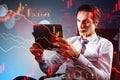 Young european businessman with tablet and abstract downward red forex chart on blurry background. Crisis, recession and economic Royalty Free Stock Photo