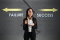 Young european businesswoman with coffee cup and failure and success arrows sketch on concrete background. Direction, growth, Royalty Free Stock Photo