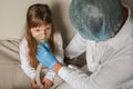 Young European doctor helping a little girl with a spray mask. Doctor applying inhalation medication therapy on little