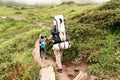 A young European family of tourists, a father with heavy backpack and a young son waiking on the mountain trails. Royalty Free Stock Photo