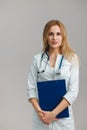 Young European Female Doctor Portrait with stethoscope and folder wearing white robe Royalty Free Stock Photo