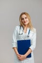 Young European Female Doctor Portrait with stethoscope and folder wearing white robe Royalty Free Stock Photo