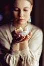 Young european girl holding a gemstone with boths hands in front of her. Mystical woman. Occult, witchcraft scene. Close