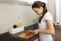 Young European girl cuts tomato
