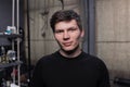 A young European guy portrait with dark hair in a black sweatshirt in a hairdresser Royalty Free Stock Photo