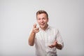 Young european man, laughing, pointing with finger at someone, something, on white background. Royalty Free Stock Photo