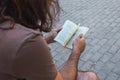 Young European man reading a book at a cobblestone park