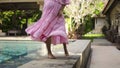 European pregnant girl  stay in the backyard with a green garden in a beautiful long pink dress Royalty Free Stock Photo