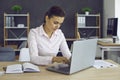 Young european woman businesswoman working in office on laptop with electronic documents.