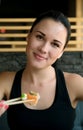 Young European woman eating sushi in an Asian restaurant