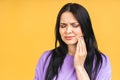 Young European woman isolated over yellow background suffering from severe toothache, feeling pain so strong that she is pressing Royalty Free Stock Photo