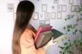 Young european woman with long hair holding old thick photo albums, family archive, concept of genialogy, memory of ancestors,