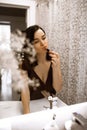 a young european woman looks in the mirror, european lady paints her lips and is going on a date Royalty Free Stock Photo