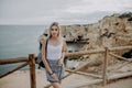 Young european woman tourist with a backpack looking at the sea while standing on the view point with the scenic beauty landscape. Royalty Free Stock Photo