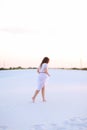 Young european woman wearing white dress walking barefoot on san Royalty Free Stock Photo