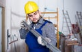 Worker is working with level near the wall at the object indoors. Royalty Free Stock Photo