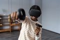 Excited afro woman wear vr glasses hold joystick experience of virtual reality headset, soft focus