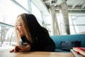 Young excited asian female IT employee using mobile phone on sofa at table Royalty Free Stock Photo