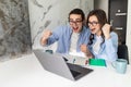 Young excited couple feeling ecstatic by online win looking at laptop screen at home motivated by achievement or great result. Royalty Free Stock Photo