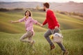 A young excited couple running on a meadow holding by hands while going to picnic. Relationship, love, together, picnic, nature Royalty Free Stock Photo